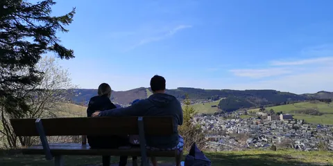 Zwei Wanderer auf einer Bank mit Blick über Willingen