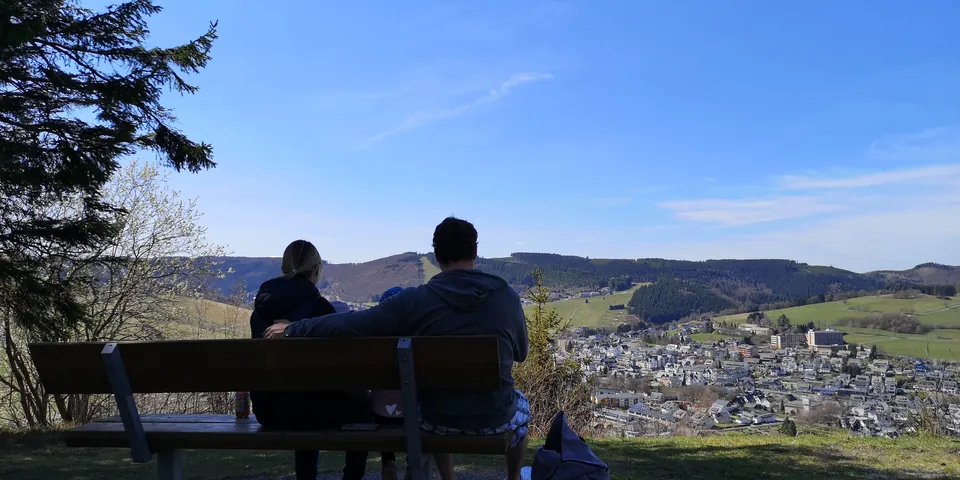Zwei Wanderer auf einer Bank mit Blick über Willingen