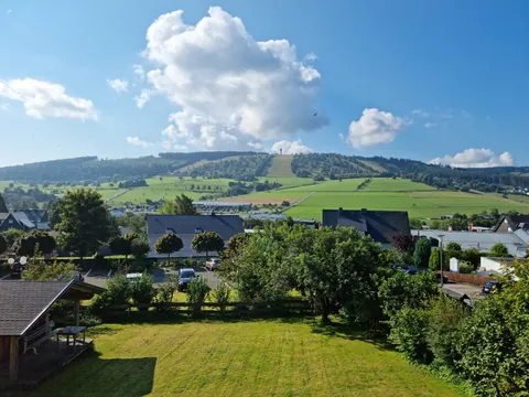 Blick über den Garten des Magdalenenhofs zur Skipiste am Ettelsberg