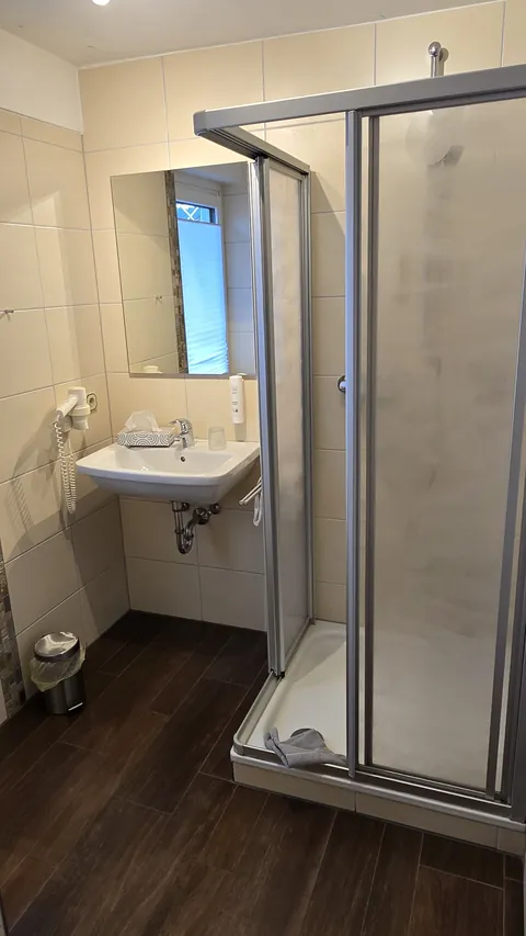 Bad im Einzelzimmer mit Dusche und Waschbecken