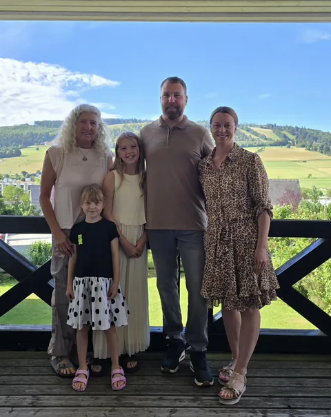 Die Gastgeberfamilie auf dem Balkon des Magdalenenhofs, im Hintergrund die Berge