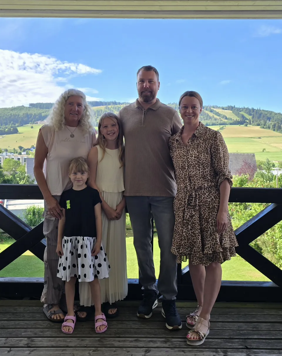 Die Gastgeberfamilie auf dem Balkon des Magdalenenhofs, im Hintergrund die Berge