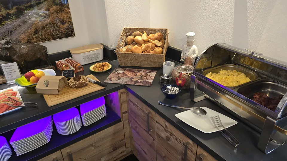 Frühstücksbuffet mit Brötchen, Rührei und Obst