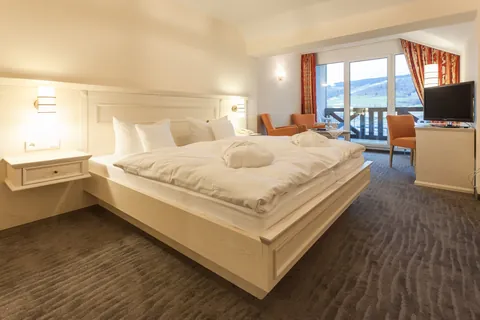 Komfort-Doppelzimmer mit großem Bett, Sitzecke und Balkontür