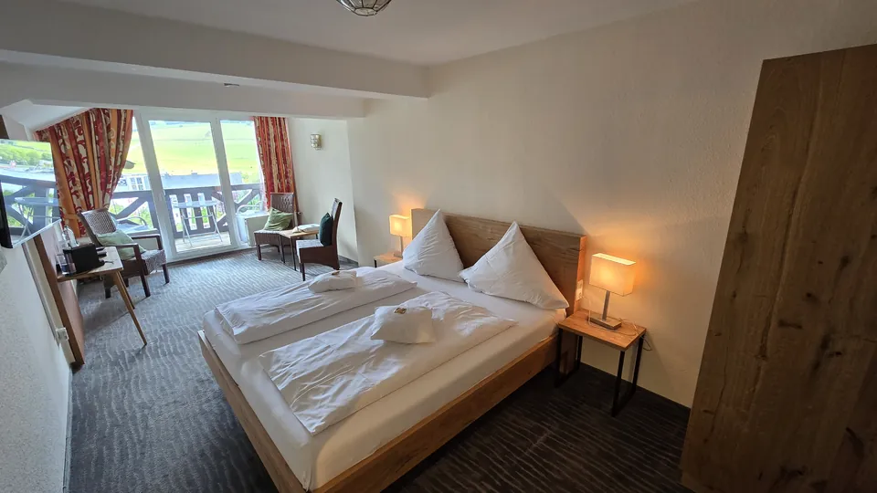 Komfort-Doppelzimmer mit Doppelbett, Sitzecke und Balkontür