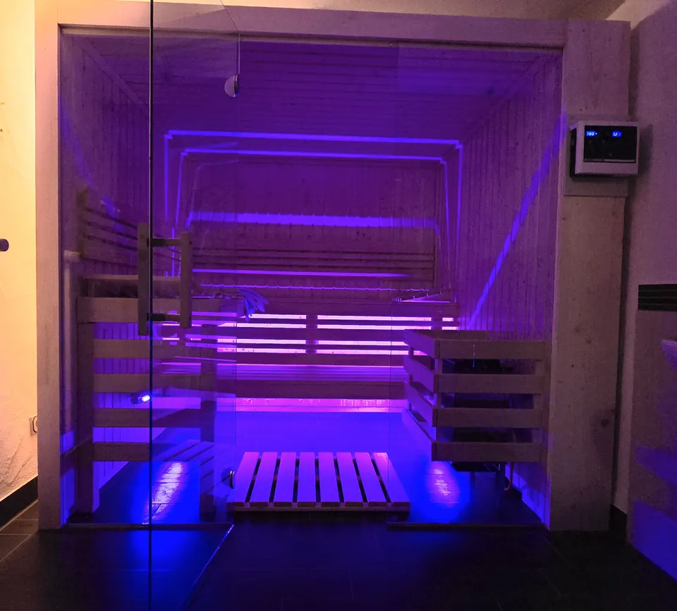 Wellnest mit violettem Licht und Saunabänken